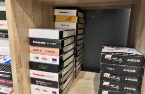 How long do VHS tapes last? A shelf of VHS tapes kept in a home office, the kind of everyday storage that decides how long do VHS tapes last.